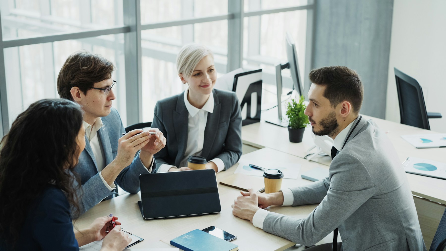 Four business colleagues discussing work around a table.