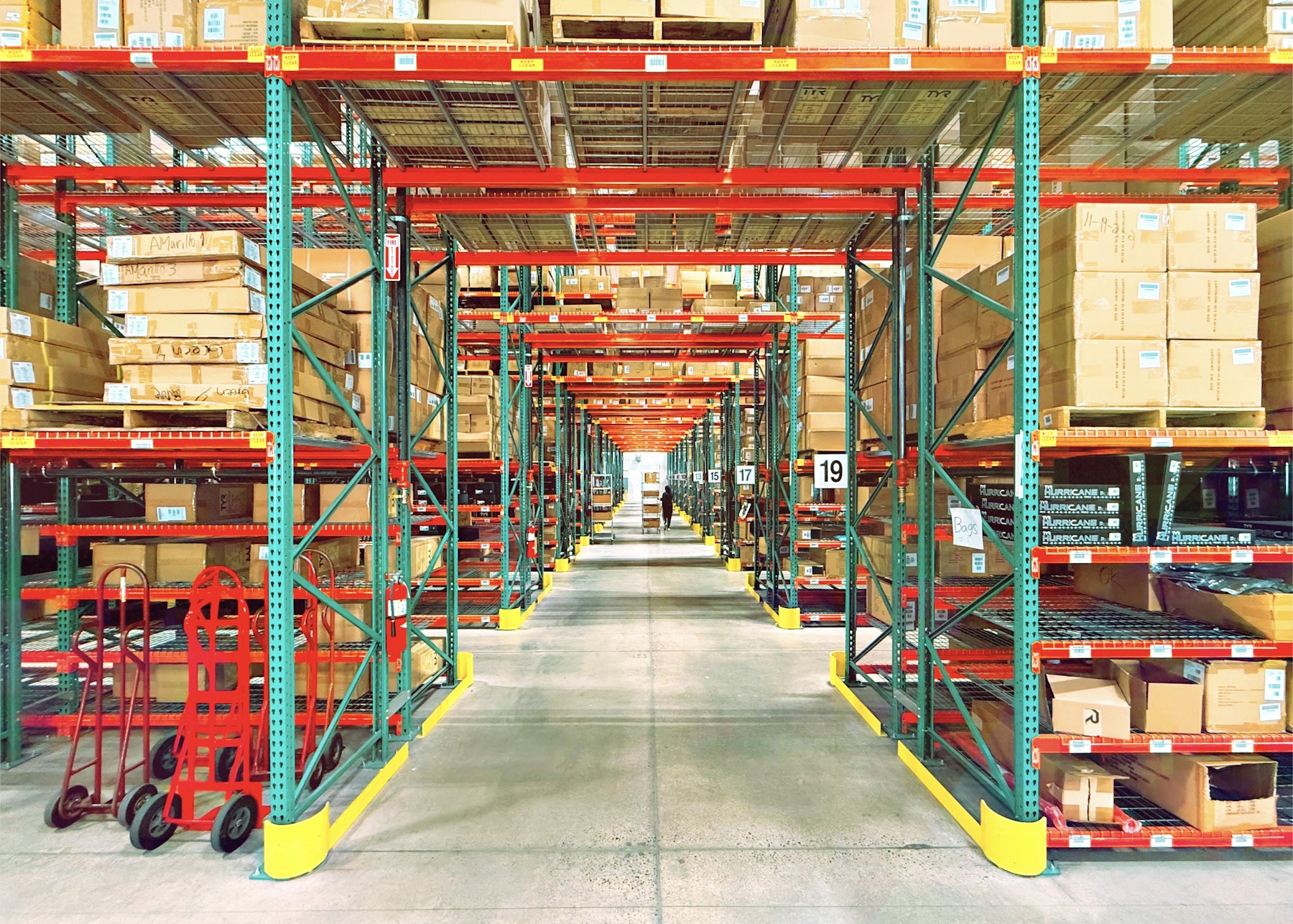 Long warehouse aisle lined with organized racks and cartons.