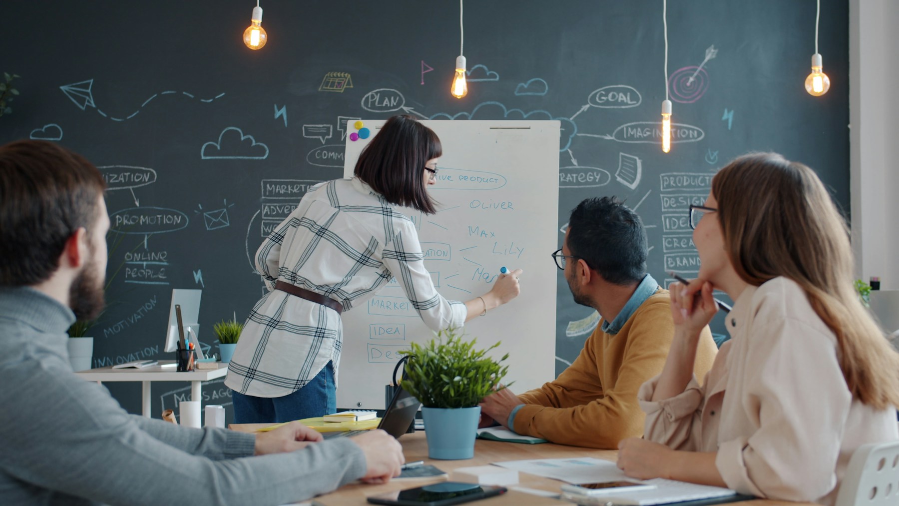 Colleagues discussing ideas around a whiteboard.